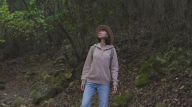Sırt çantalı genç bir kız ormanda seyahat ediyor. Ormanda ve dağlarda turist yürüyüşü. yürüyüş ve macera konsepti.