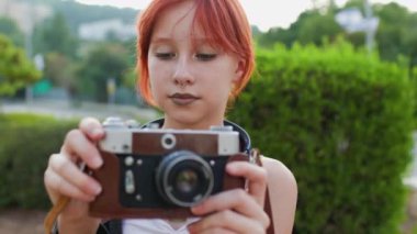 Kameralı genç kız. Genç bir kız fotoğraf çekiyor. Genç, sokakta kamera kullanıyor..