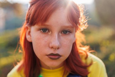 Yüzünde piercing olan güzel, güzel, güzel bir kız. Güneşli bir günde sokakta gülümseyen tasasız bir kadın. Sokaklarda olumlu bir genç.