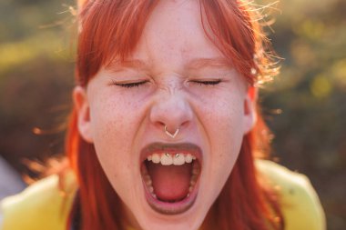 Kızgın ve çığlık atan genç bir kız. Bağıran üzgün kız, piercingli genç kız. Şok ve duygusal çöküntü, depresyon.