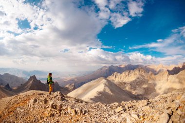Dağlarda macera. Dağlarda sırt çantalı bir dağcı. Dağlara seyahat eden bir turist. Doğada aktif bir eğlence. dağcılık ve kaya tırmanışı.