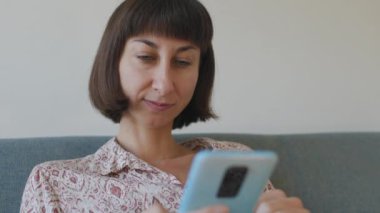 Sosyal ağ uygulamalarını kullanarak internette gezinen cep telefonu olan bir kadın.