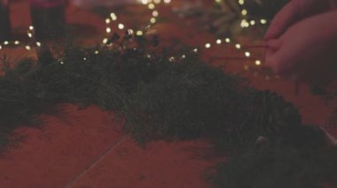 Bir kadın köknar dallarından Noel kompozisyonu yapar. Kadın eli, el yapımı Noel dekorasyonu yaratır. Yeni yıl kutlaması. Kış tatili.