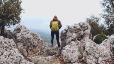 Başarılı bir kadın yürüyüşçü dağ zirvesinde yürüyüş yapıyor. Seyahat ve yürüyüş konsepti. Yürüyüş ve kaya tırmanışı. Spor ve eğlence. Hindi. Antalya. Geyikbayiri
