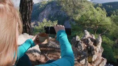 Aktif bir genç kız termostan bir fincan sıcak çay doldurur ve yürüyüşe ara verir..