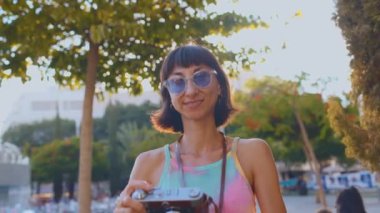 Kız şehirde fotoğraf çekiyor. Kameralı kadın fotoğrafçı dışarıda fotoğraf çekiyor. Şehirde film kamerası olan genç bir kız. Kız fotoğraf çekiyor. seyahat ve macera.