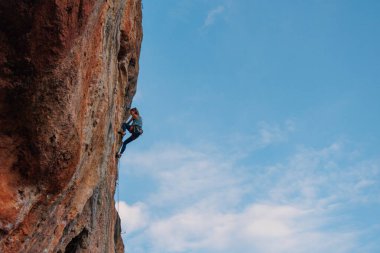 Dağcı kız. Kaya tırmanışçısı kız bir kayaya tırmanıyor. Spor ve açık hava eğlencesi