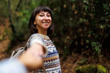 Beni takip edin. Sırt çantalı güzel bir bayan gezgin dağın yamacında el ele tutuşarak duruyor. Bir çift gezgin birlikte..