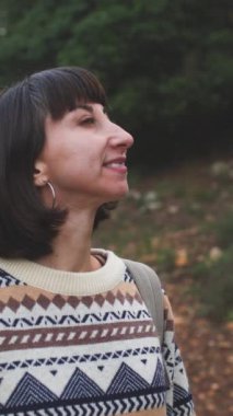 Dikey çekim. Süslü ve sırt çantalı bir kadın seyahat ediyor. Dağlarda yürüyüş. Macera ve yürüyüş. Genç mutlu turist kadın doğada dinleniyor. moda ve tarz.