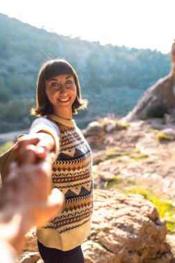 Beni takip edin. Erkek arkadaşına yardım eden mutlu kadın turistin portresi. Kız gülümsüyor. Yürüyüş ve yürüyüş. Spor ve sağlıklı yaşam tarzı kavramı. Sırt çantalı kız.