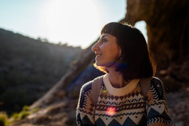 Sırt çantalı kız. Dağlardaki mutlu kadın turistin portresi. Gezinti ve yürüyüş. Spor ve sağlıklı yaşam tarzı konsepti.