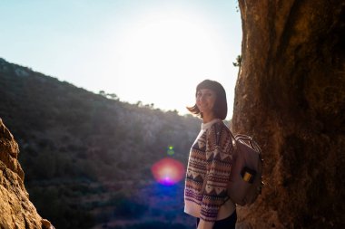 Sırt çantalı kız. Sırt çantalı bir kadın mağarada duruyor. Kız mağarayı keşfediyor. Speleolog. Mağara turu.