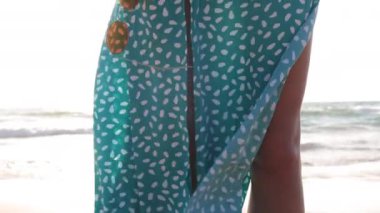 Yaz havası. Elinde gözlük olan bir kız kumsalda yürüyor. İnce bir kız denizde bir yaz tatilinin tadını çıkarıyor..