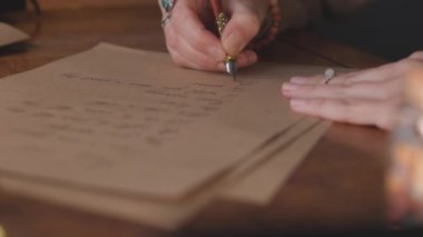 Kalemle yazı yazan bir kızın elini kapat. Mektup yazan profesyonel bir kaligraf. El yazısı sanatı. Yavaş çekim.