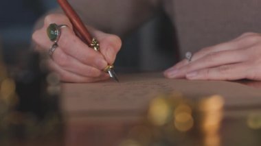 Kalemle yazı yazan bir kızın elini kapat. Mektup yazan profesyonel bir kaligraf. El yazısı sanatı. Yavaş çekim.