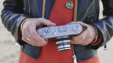 Fotoğrafçı kamerayı ayarlar. Kız seyahat eder ve manzaranın fotoğrafını çeker. Film kamerası olan şık bir kız. Maceralar ve yolculuklar.