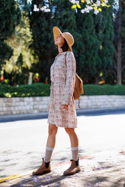 Hareket halindeki kız şehir parkında mutluluğunu ifade ediyor. Çekici, neşeli bir kadın iyi bir günde kendini özgür ve neşeli hisseder. Parkta yürü.