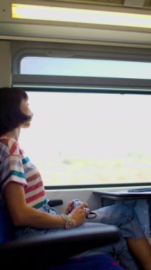 Trenle yolculuk. Çekici bir kız demiryolu ile seyahat eder ve trenin penceresinden çekimlerin fotoğrafını çeker..