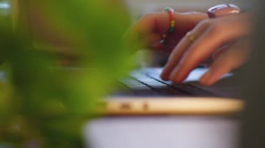 Dizüstü bilgisayar kullanan bir kızın yan görüntüsü. Genç bir kadının ellerine yakın çekim. Uzaktan çalışıyor, e-postaları cevaplıyor ve işleri internetten tamamlıyor. İş kavramı ve çevrimiçi kaynaklar.