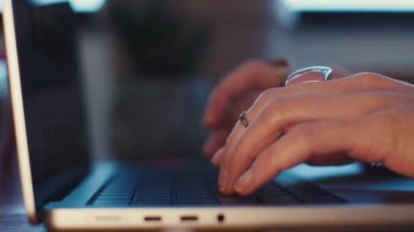 Dizüstü bilgisayar kullanan bir kızın yan görüntüsü. Genç bir kadının ellerine yakın çekim. Uzaktan çalışıyor, e-postaları cevaplıyor ve işleri internetten tamamlıyor. İş kavramı ve çevrimiçi kaynaklar.