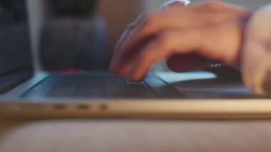 Laptop kullanan ve kahve içen bir kızın yan görüntüsü. Genç bir kadının ellerine yakın çekim. Uzaktan çalışıyor, e-postaları cevaplıyor ve işleri internetten tamamlıyor. İş kavramı ve çevrimiçi kaynaklar.