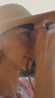 Genç bir gezgin elinde bir film kamerası tutuyor ve fotoğraf çekiyor. Seyahat, fotoğraf ya da doğayla iç içe olan bir kız. Güzel genç bir kadın yürürken fotoğraf çekiyor. hippi kız