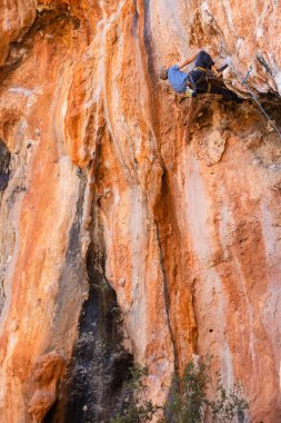 Olağanüstü bir spor, güçlü bir adam kayaya tırmanır, bir kaya tırmanıcısı zor bir yola tırmanır..