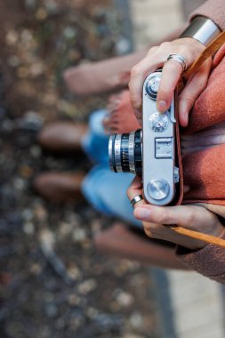 Kız yürürken kamerayı tutuyor. Moda ve tarz. hippi kız film kamerasıyla fotoğraf çekiyor. Yaşam tarzı konsepti, kameraya odaklan.