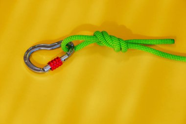 Güvenli bir düğüm ve karabina ile ip. Kaya tırmanışı ve dağcılık ekipmanları. Güvenilir bağlantı. Güvenlik halatı. Güvenilirlik ve dayanıklılık kavramı.