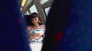 Trendeki kadın. Trenle seyahat ederken akıllı telefonlu genç bir kadın. seyahat konsepti. Şık ve şık..