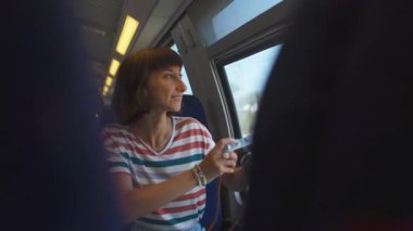 Kameralı kız. Tren yolculuğu. Genç bir kadın, elinde kamerayla tren yolculuğunun tadını çıkarıyor. Turist kamerada güzel turistik yerlerin fotoğraflarını çeker. Kız film kamerası kullanıyor..