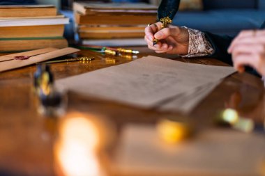 Kalem ve mürekkebi olan bir kadın. Bir kız kalemini mürekkebe batırır ve yazar. Genç bir kadın dolma kalemle mektup yazıyor..