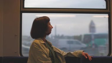 Trendeki mutlu kadın. Kadın gezgin trenin penceresinden dışarı bakıyor ve yolculuğun tadını çıkarıyor. tren yolcu.
