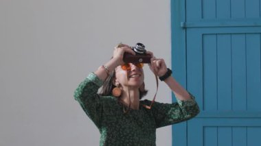 Kameralı kız. Turist tatilden zevk alıyor kameralı şehir fotoğrafları çekiyor, elinde kamera olan şık bir kız ve manzaranın fotoğraflarını çekiyor. seyahat blogcusu resim çekiyor.