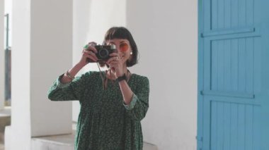 Kameralı kız. Turist tatilden zevk alıyor kameralı şehir fotoğrafları çekiyor, elinde kamera olan şık bir kız ve manzaranın fotoğraflarını çekiyor. seyahat blogcusu resim çekiyor.