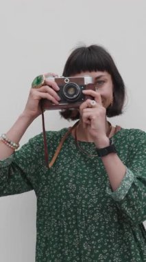 Dikey çekim. Gezgin tatilin tadını çıkarıyor. Kamera ile şehir fotoğraflarını çekiyor. Kadın elleri kamerayı tutuyor ve kentin işaretlerini çekiyor. Seyahat blogcusu fotoğraf çekiyor.