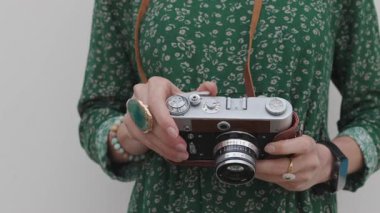 Kız yürürken kamerayı tutuyor. Moda ve tarz. hippi kız film kamerasıyla fotoğraf çekiyor. Yaşam tarzı konsepti, kameraya odaklan. 