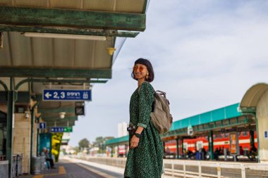 Tren istasyonunda durmuş treni bekleyen kız. Sırt çantalı kadın treni bekliyor. özgürlük ve seyahat kavramı.