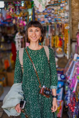 Hediyelik eşya dükkanındaki kadın. Bir kız hediyelik eşya dükkanında kendisi, arkadaşları ve ailesi için hediyeler seçiyor. Kız seyahat ediyor.