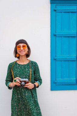 Gezgin tatilin tadını çıkarıyor. Kamera ile şehir fotoğraflarını çekiyor. Kadın elleri kamerayı tutuyor ve kentin işaretlerini çekiyor. Seyahat blogcusu fotoğraf çekiyor.