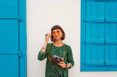 Gezgin tatilin tadını çıkarıyor. Kamera ile şehir fotoğraflarını çekiyor. Kadın elleri kamerayı tutuyor ve kentin işaretlerini çekiyor. Seyahat blogcusu fotoğraf çekiyor.