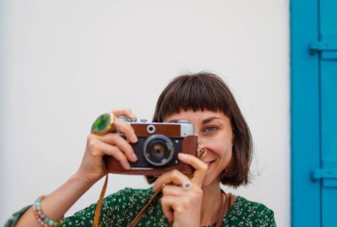 Gezgin tatilin tadını çıkarıyor. Kamera ile şehir fotoğraflarını çekiyor. Kadın elleri kamerayı tutuyor ve kentin işaretlerini çekiyor. Seyahat blogcusu fotoğraf çekiyor.