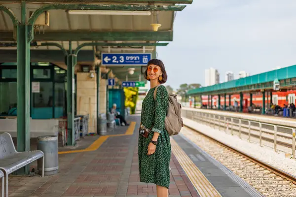 Tren istasyonunda durmuş treni bekleyen kız. Sırt çantalı kadın treni bekliyor. özgürlük ve seyahat kavramı.