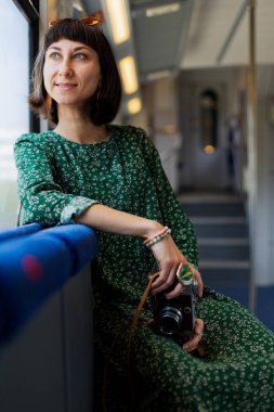 Tren yolculuğu. tren yolcusu. Kameralı genç ve güzel bir kız tren yolculuğunun tadını çıkarıyor. İyi yolculuklar..