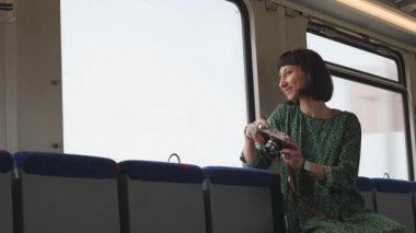 Kameralı kız. Kameralı genç ve güzel bir kız tren penceresinden fotoğraf çekiyor. Tren yolculuğu. tren yolcu.