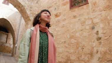 Turist eski kentin caddesi boyunca yürür ve manzaranın fotoğraflarını çeker. Şehirde kameralı bir kız. seyahat ve macera.