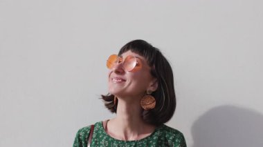 Şehirdeki kız. Kamera karşısında gülümseyen, kendinden emin ve neşeli görünen, şehir hayatından zevk alan şık bir kızın portresi. Kadın yüzü.