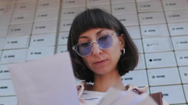 Zarflara yakın çekim. Posta alan kız, yazışmalara bakan kız bildirimi, banka hesap bildirimi.