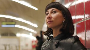 Metroda treni bekleyen kız. Yorgun kız metroda oturuyor ve treni bekliyor. İşten dönen kadın..
