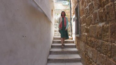 Kız güvenli bir şekilde eski şehrin caddesinde yürüyor. Sırt çantalı genç ve çekici bir turist eski şehrin caddesinde geziniyor, mimariye hayran kalıyor, etrafa bakıyor.. 